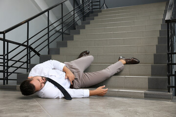 Man fallen down stairs suffering from pain indoors, space for text - obrazy, fototapety, plakaty