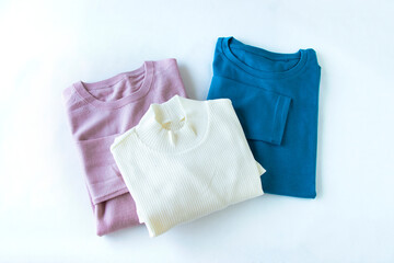 ターコイズブルーのTシャツと白のハイネックのシャツとくすみピンクのセーター（女性用）