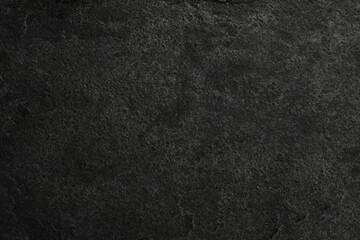 Texture of dark grey stone surface as background, closeup