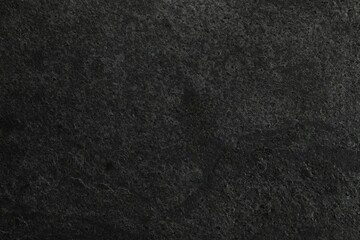 Texture of dark grey stone surface as background, closeup
