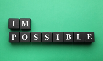 Motivation concept. Changing word from Impossible into Possible by removing black wooden cubes on...