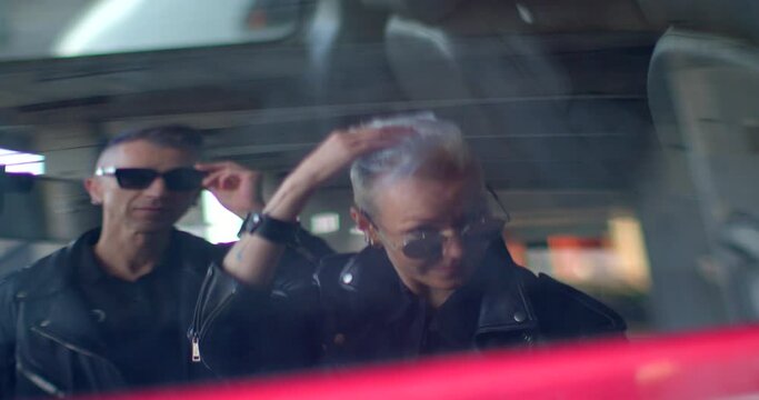 Couple poses in the reflection of a car window, spending time together, engaging in shared activities and cultivating a sense of togetherness. Car Window Provides reflective surface in urban setting.