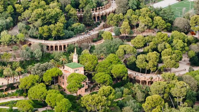 Aerial drone view of Park Guell. Antoni Gaudi architecture. A lot of greenery around, tourists, Barcelona, Spain