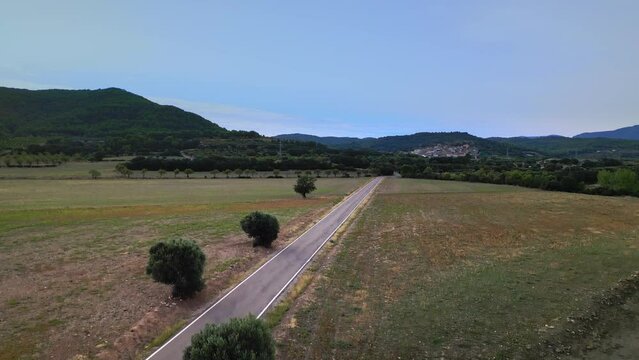 Carretera recta en media monta&ntilde;a capturada en 4K desde el aire: un viaje visual &uacute;nico por un camino sereno y pintoresco.