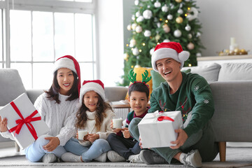 Happy family with presents at home on Christmas eve - Powered by Adobe