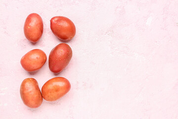 Fresh raw potatoes on pink background
