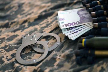 Ukrainian army machine gun belt shells, handcuffs and bunch of hryvnia bills on military uniform....