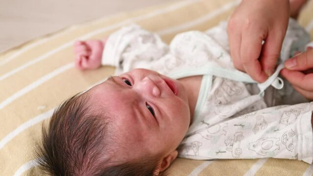 産着を聞く新生児の赤ちゃんの動画　出産や産後のイメージ