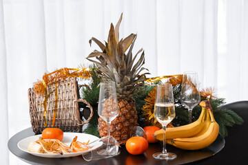Christmas tree with food and drink on table in messy room after New Year party, closeup
