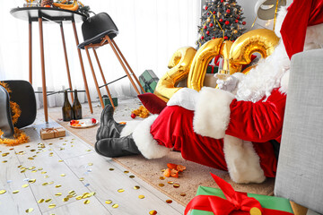 Drunk Santa Claus in messy living room after New Year party