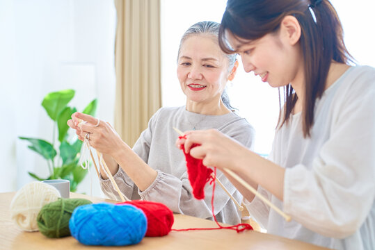編み物をするシニア女性と若い女性