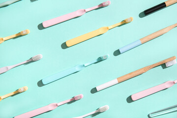 Wooden and plastic colorful toothbrushes on color background.