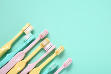Colorful plastic toothbrushes on color background.