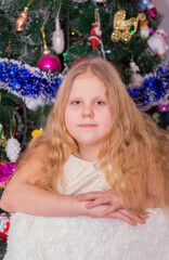 A beautiful elegant girl near the Christmas tree in the New Year. Holiday. New Year. The child is a model.