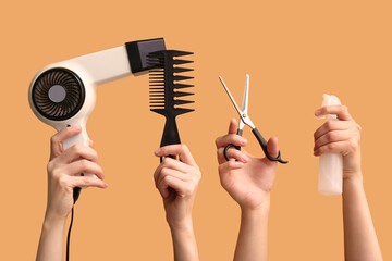 Many female hands with hair supplies on orange background.