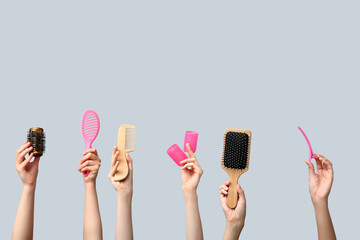 Many female hands with hair supplies on white background.