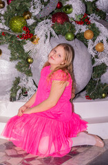 A beautiful elegant girl near the Christmas tree in the New Year. Holiday. New Year. The child is a model.