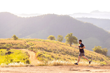 A man running outdoors amid a beautiful landscape. An image to inspire sports and wellness....