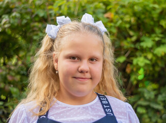 A girl in a beautiful elegant modern school uniform on the Day of Knowledge at school.