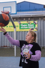A girl is playing ball on the playground.