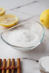 Baking soda and whole lemon on table 