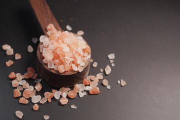 Raw dried pink Himalayan salt on wooden spoon 