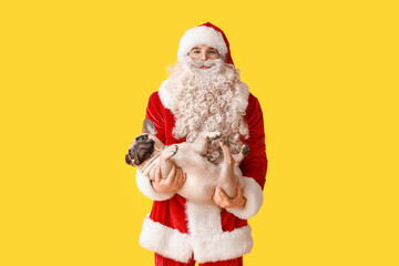 Fototapeta na wymiar Santa Claus with cute French bulldog on yellow background