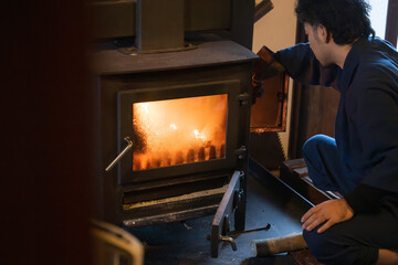 薪を薪ストーブにいれる男性　日本の冬の田舎の冬支度のイメージ 本当の丁寧な暮らし - obrazy, fototapety, plakaty
