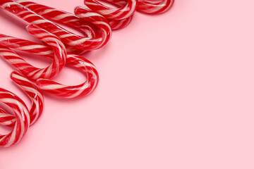 Fototapeta premium Many Christmas candy canes on pink background
