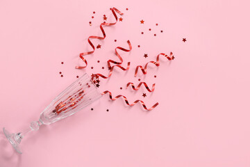 Champagne glass with Christmas decor on pink background