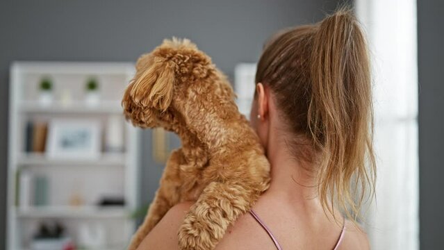 Young caucasian woman with dog hugging at home