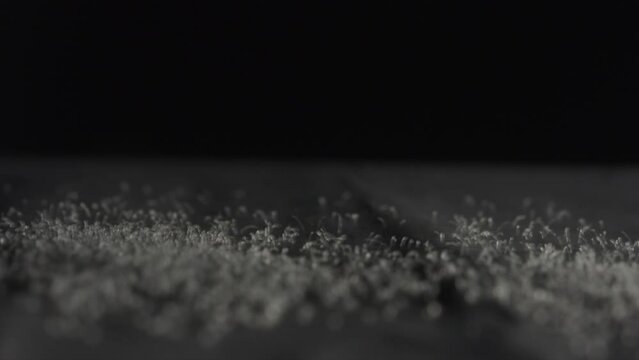 White particles shaking on a dark background