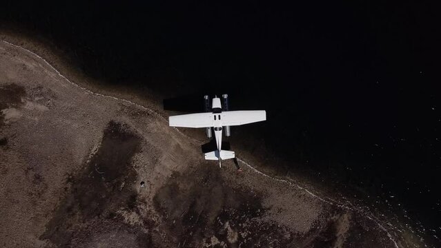 Aerial Top Down Dolly Out Above Seaplane Moored at Lake Shoreline