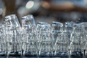 Crystal Glasses Stacked Against a Window Covered with Rain Drops.