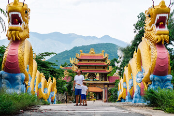 Dad and son tourists in buddhist temple Vietnam. Chinese golden dragon statue - obrazy, fototapety, plakaty