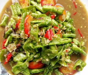 Fresh green salad with vegetables and peppers on a white plat