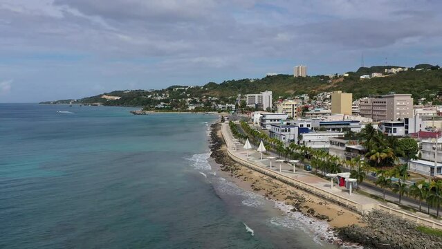 Drone footage of coastal roads, seafront buildings and Rompeolas Beach in Aguadilla, Puerto Rico