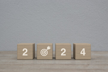 2024 letter with goal icon on wood block cubes on wooden table over white wall background, Happy new year 2024 success concept - obrazy, fototapety, plakaty