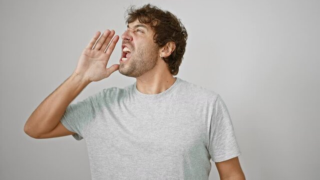 Furious young blond man screams loud in rage, hand on mouth amplifying his voice. captured an isolated white background, communicating a raw emotive outburst.