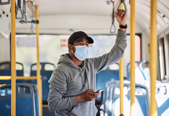 Man in bus with mask, phone and travel to city in morning, checking service schedule or social media. Public transport safety in covid, urban commute and person in standing with smartphone connection