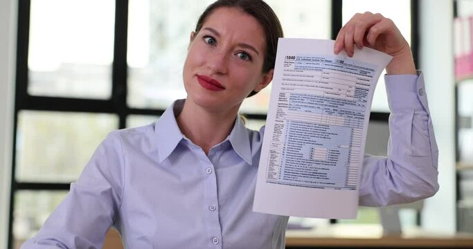 Beautiful woman showing tax form and dollars
