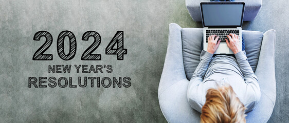 2024 New Years Resolutions with man using a laptop in a modern gray chair