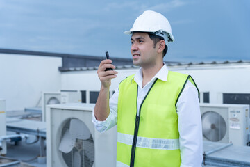 Asian maintenance engineer work on the roof of factory. contractor inspect compressor system and...