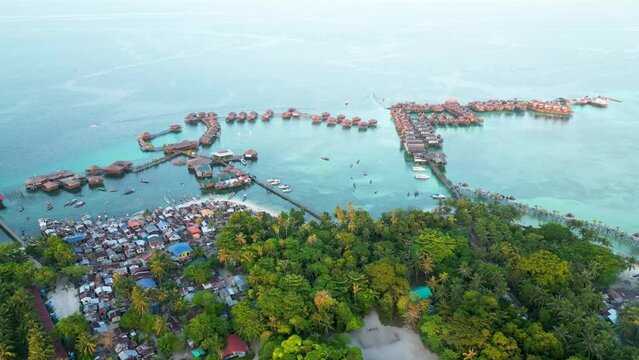 Aerial hyper-lapse of Sabah's Mabul Island, an captivating scenery of the Bajau community and the Water Village Resort, presenting a dynamic tapestry of life in this coastal haven of Malaysia.