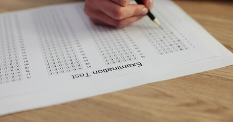 Woman hand holding pencil and writing selected choice on answer paper