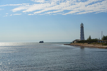 Fototapeta na wymiar Lighthouse on Cape Tarkhankut. The rocky coast of the Dzhangul Reserve in the Crimea. Turquoise sea water. Tarkhankutsky lighthouse on the Crimean peninsula.