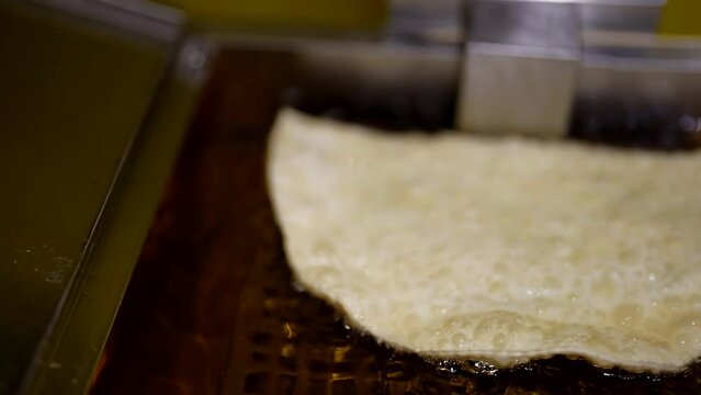 closeup view of chebureki in deep fryer, traditional meal of middle Asia, unhealthy food