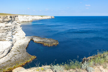 Cape Tarkhankut on the Crimean peninsula. The rocky coast of the Dzhangul Reserve in the Crimea. The Black Sea. Turquoise sea water. Rocks and grottoes of Cape Tarkhankut.