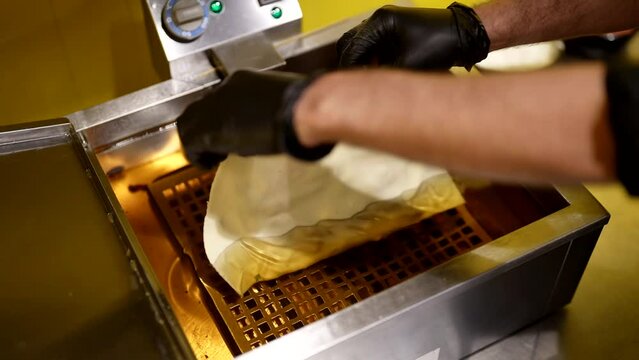 cooking cheburek in deep fryer, closeup view in professional kitchen of restaurant