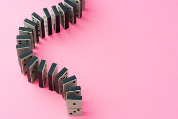 Row of domino tiles on pink studio background